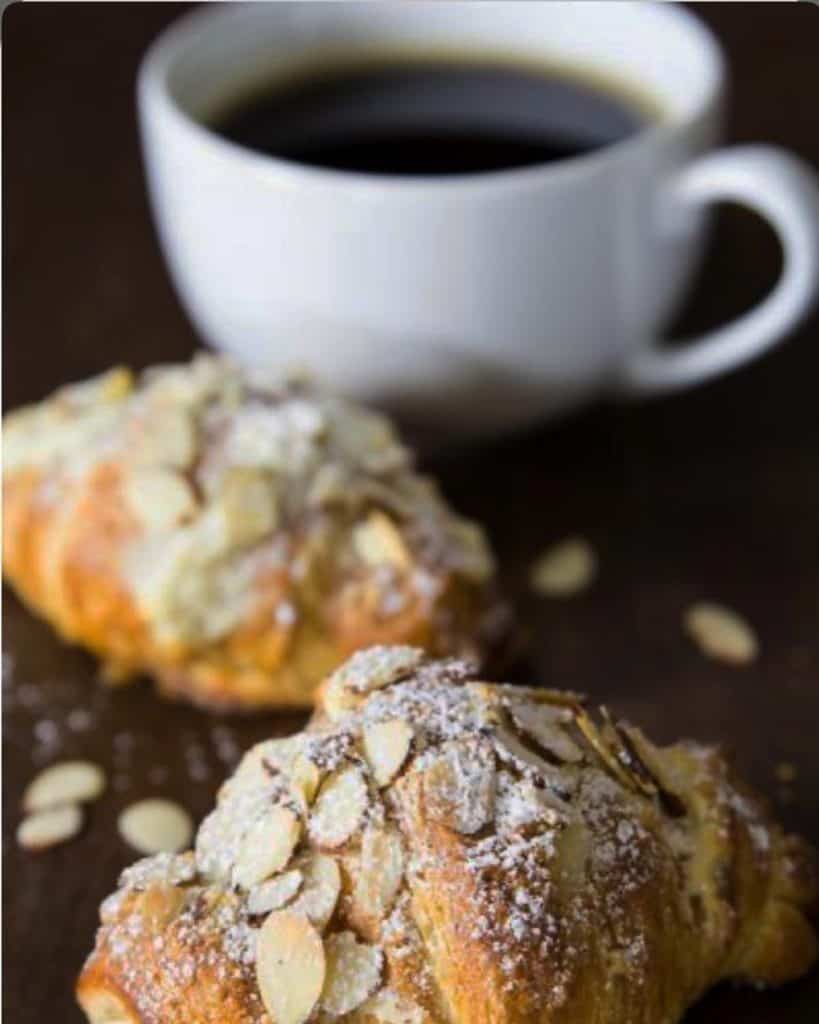 Freshly baked almond croissants with a cup of black coffee at Diamond Creek Shopping.