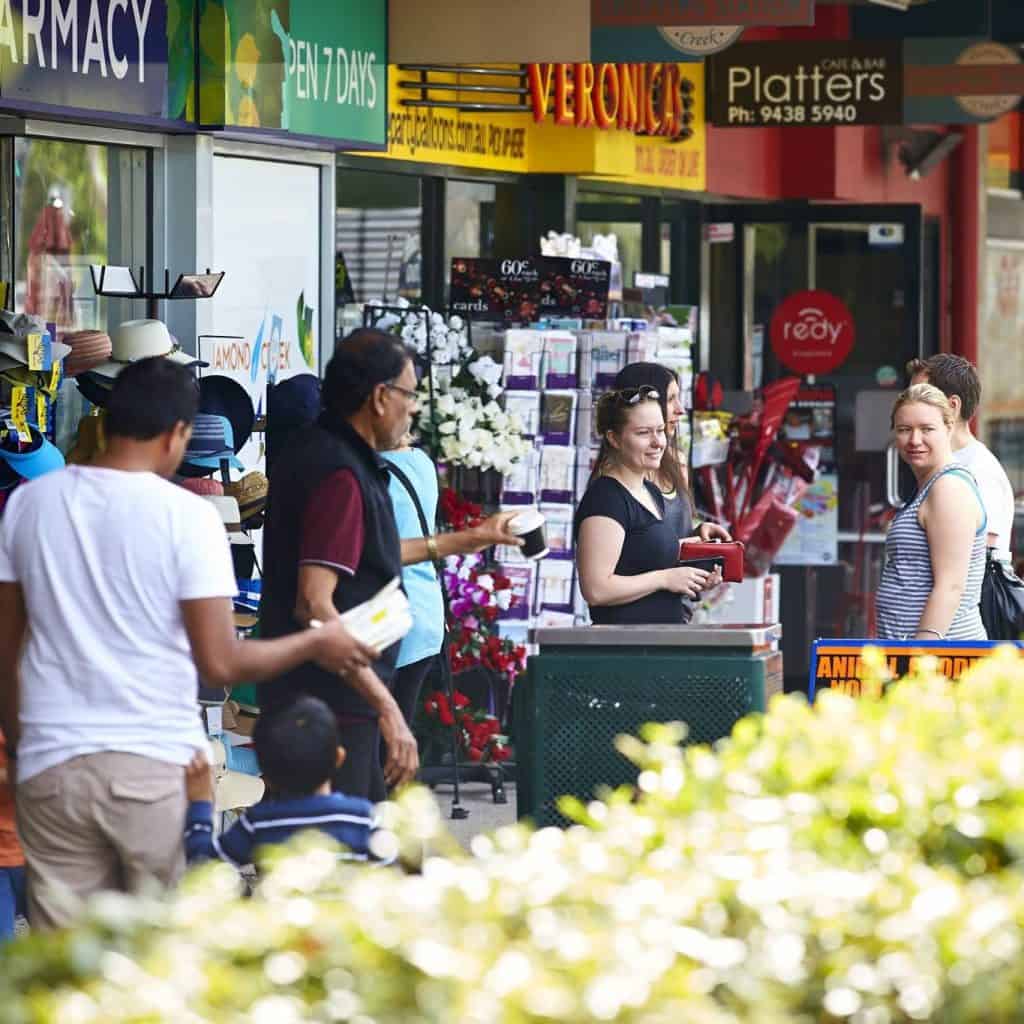 Colourful shopfront awnings and shoppers at Diamond Creek Shopping Centre in Melbourne.
