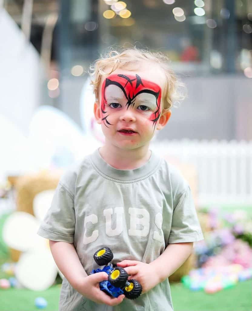 Colourful face paint on child at Diamond Creek Shopping event.