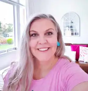 Image of a smiling woman in a pink top at Blue Hearts Counselling office.