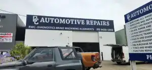 Automotive repairs shop with a vehicle parked outside, signage for RWC diagnostics and brake service.