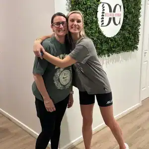 Two women smiling and hugging at DC Wellness in Diamond Creek Shopping.