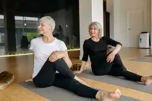 Older women practicing seated spinal stretch for flexibility and mobility.