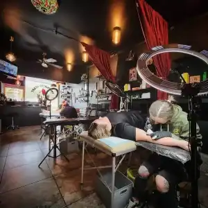 Tattoo artist performing a tattoo at The Painted Heart Tattoo Parlour in Diamond Creek, professional.