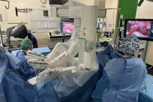 Medical team performing robotic surgery in hospital operating room.