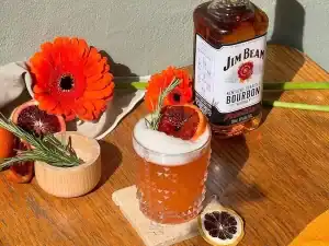 Jim Beam Bourbon whiskey with cocktail garnishes and flowers at Diamond Creek Shopping.