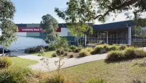 Community Bank Stadium exterior view with greenery and pathway.