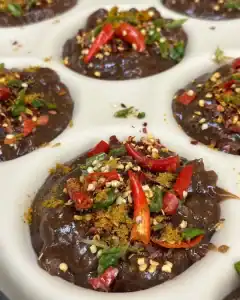 Delicious hot pies filled with pork, topped with fresh herbs and chili, perfect for lunch.