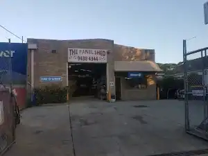 Image of The Panel Shed at Diamond Creek Shopping, featuring a brick building with signage and vehic.