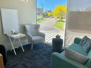 Bright waiting area with comfortable seating and large window views.
