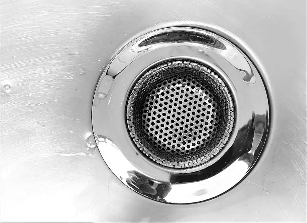 Drain cover in a stainless steel sink, close-up shot.