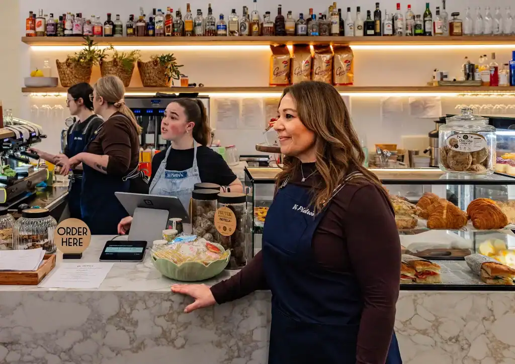 Friendly cafe staff at Diamond Creek Shopping with baked goods and drinks.