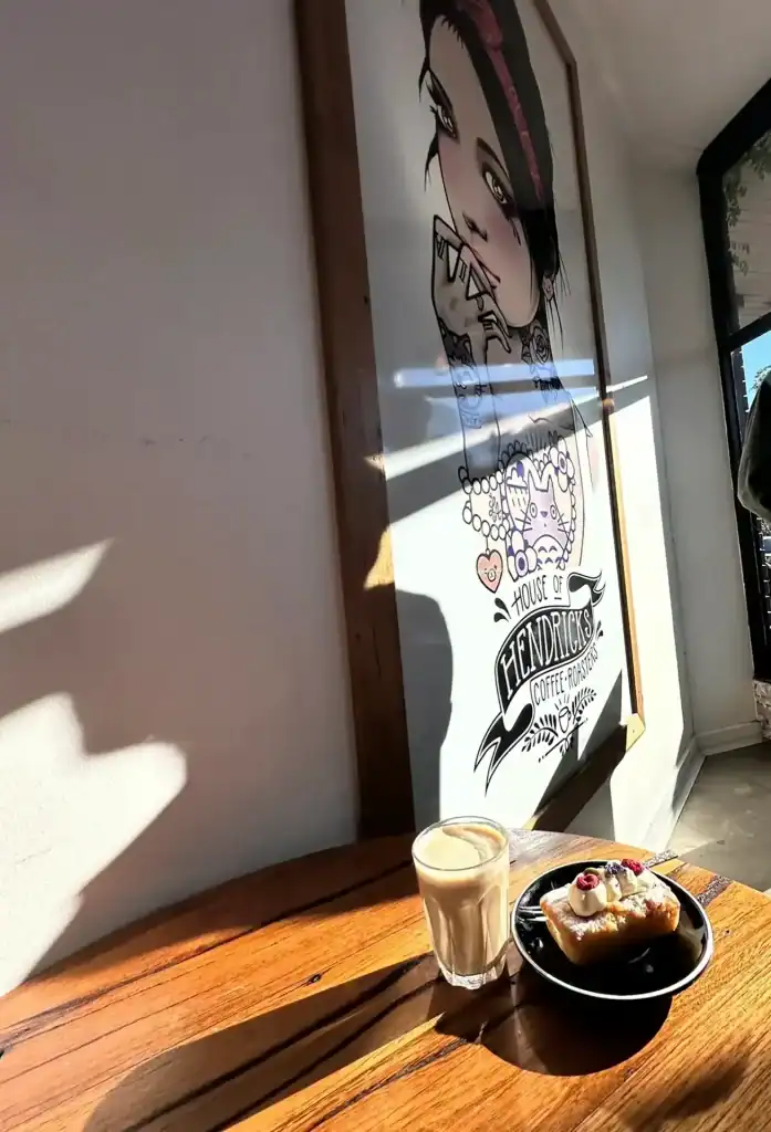 Coffee and pastry served near a large wall art at Diamond Creek Shopping.