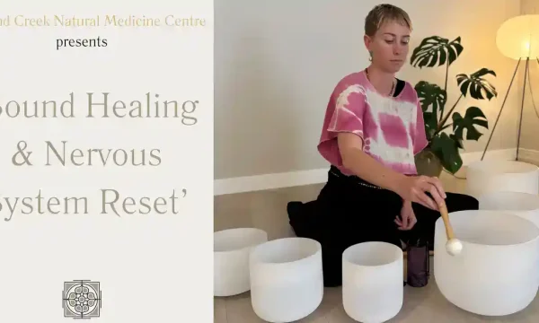 Young woman meditating with crystal singing bowls for nervous system reset.