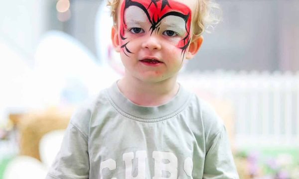 Colourful face paint on child at Diamond Creek Shopping event.