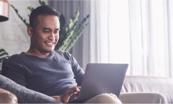 Cozy man shopping at Diamond Creek Shopping online on laptop in home relaxing.